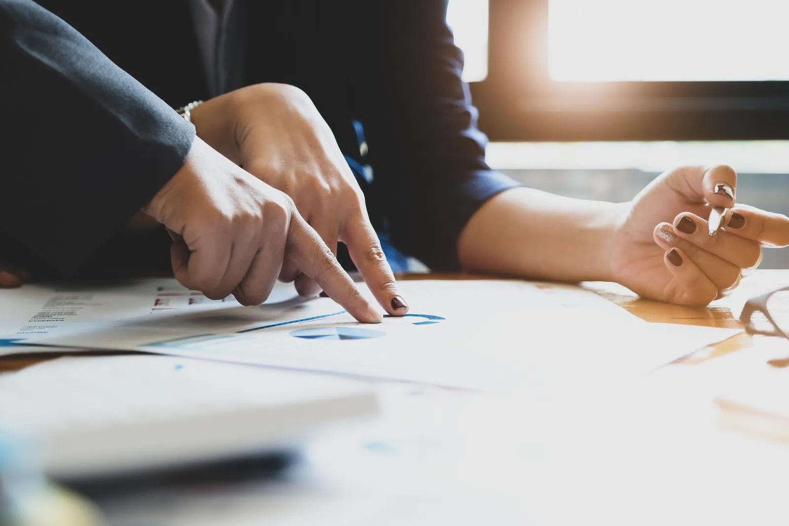 47725110 the company employee points to the budget document and makes marketing out of the budget being reviewed
